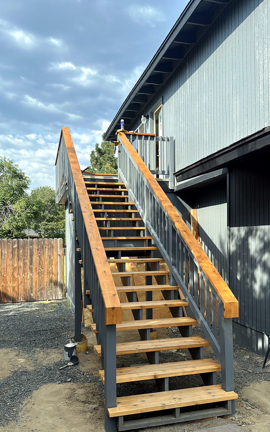 Exterior staircase with painted stringers, cedar treads, and cedar handrails