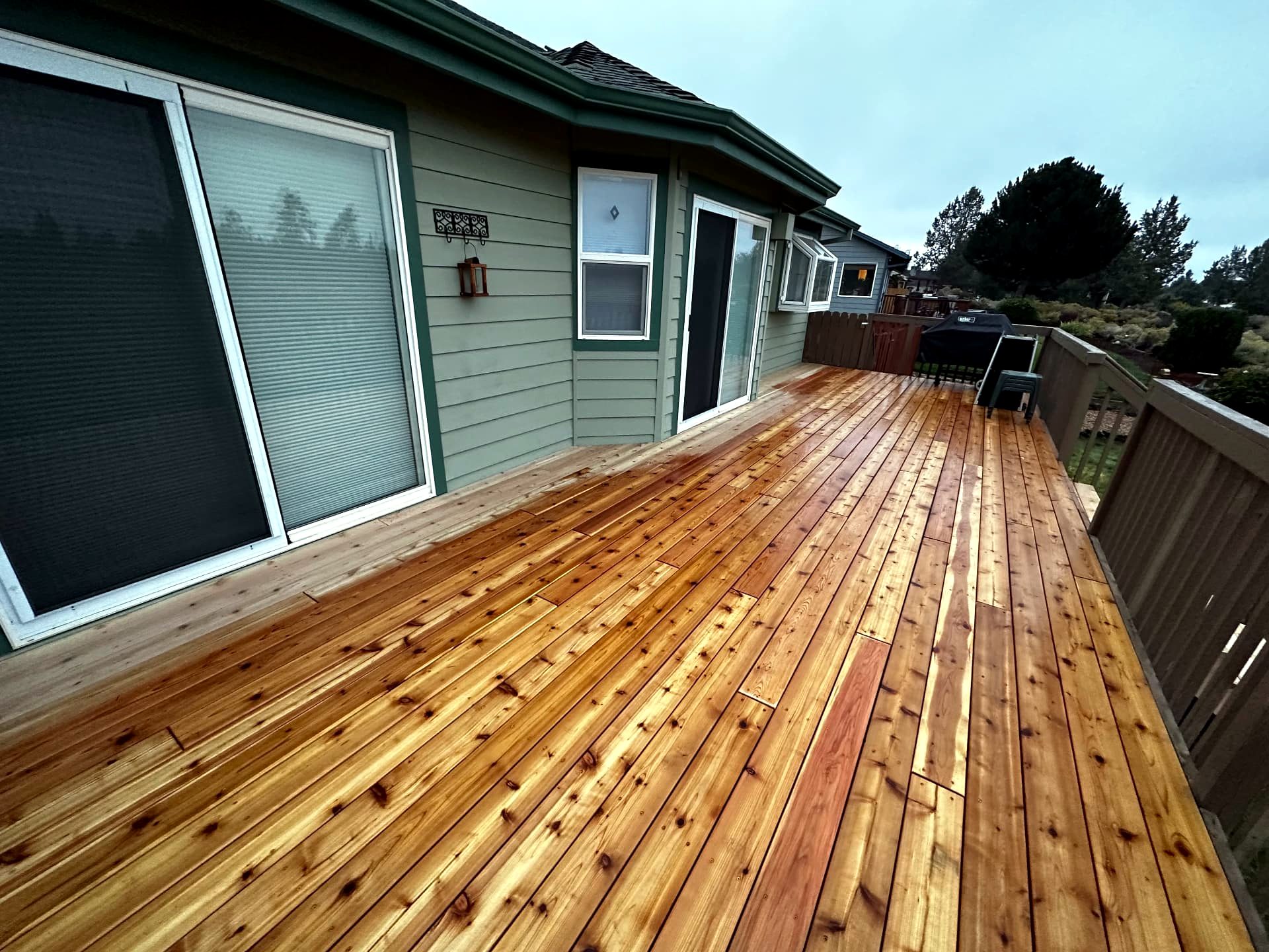 Freshly stained cedar deck boards beside sliding doors