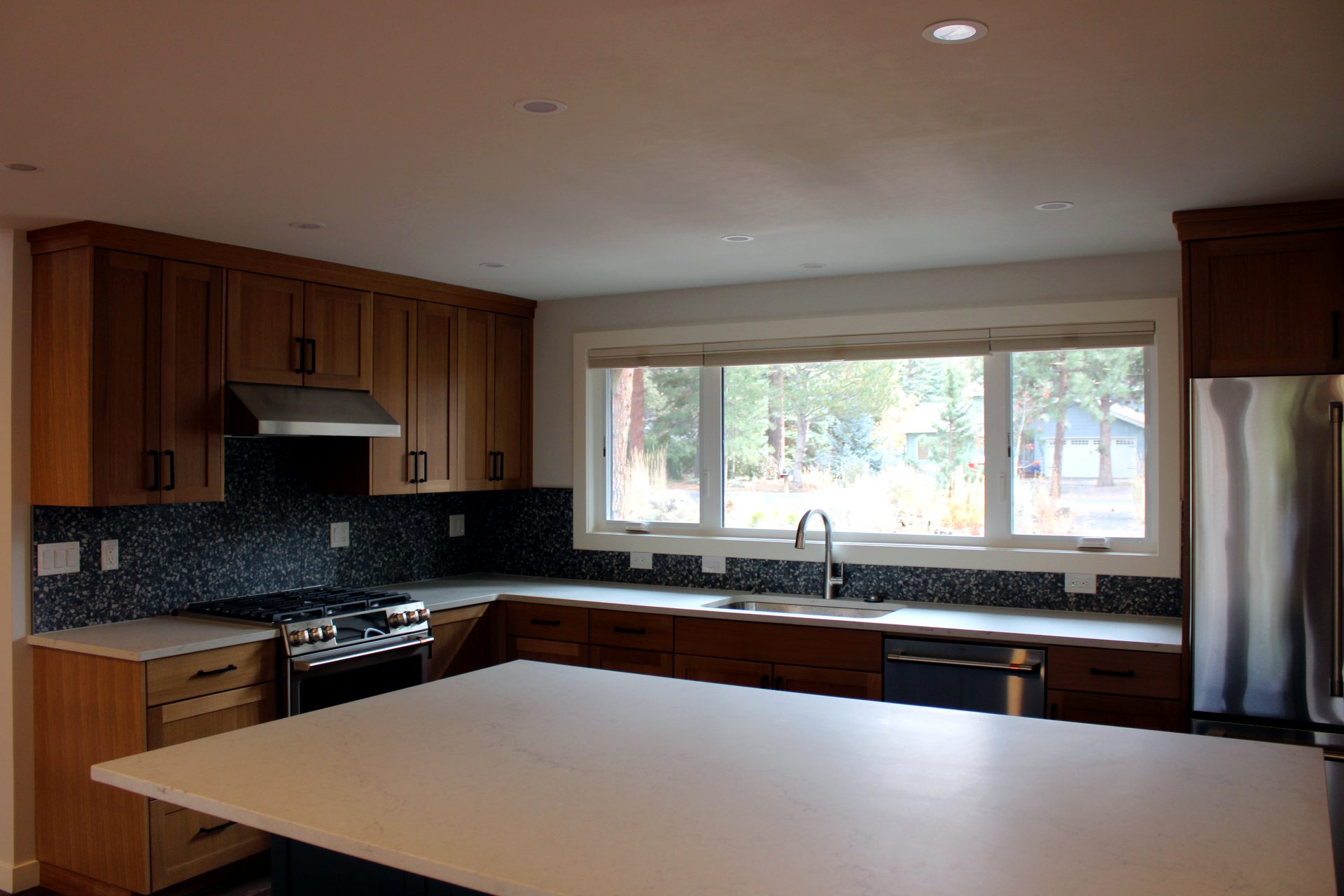 Kitchen with white oak cabinets, quartz counters, and a window over the sink